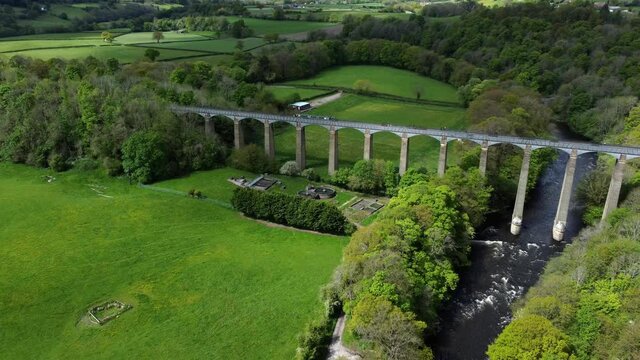 Aerial view Pontcysyllte aqueduct and River Dee canal narrow boat bride in Chirk Welsh valley countryside pull back pan right