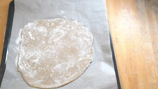 Girl cooks pizza, smears tomato paste on dough in the form of a circle. High quality 4k footage