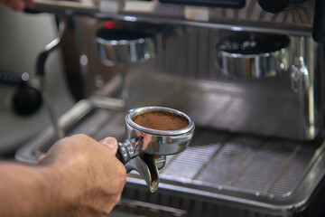 Fototapeta na wymiar barista scoop grind coffee bean for make espresso shot