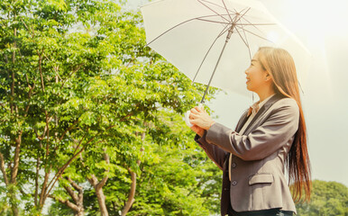 World environment day concept : business woman walks with a white umbrella in the hot sun, but she is happy to be in nature and clean air without pollution.
