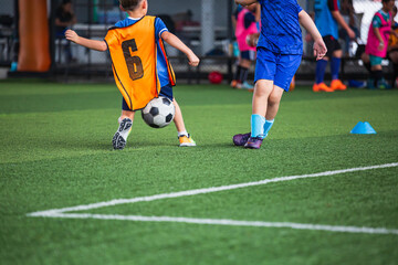 Obraz premium Children playing soccer ball tactics on grass field with for training