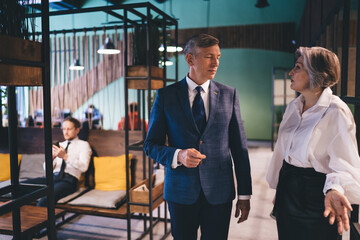 Adult male and female colleagues talking in workplace