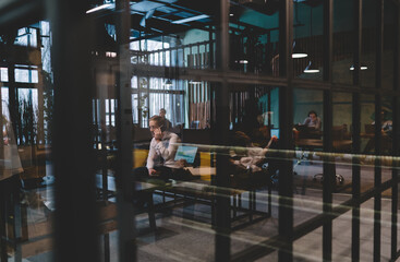 People working in spacious modern office with laptop and smartphones