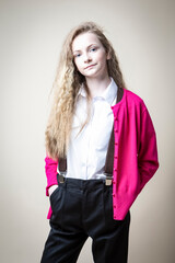 Caucasian Blond Teenage Girl in Casual Clothing with Braces Posing Against Beige