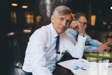 Calm male entrepreneur leaning on hand