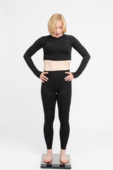 Fototapeta premium Surprised Senior Caucasian Woman Checking Her Weight With Floorstanding Weigh-Scales.