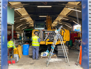 Mechanic working on crane engine.
