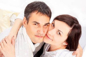 Upper View of Portrait of Caucasian Family Couple Sitting Embraced Against White