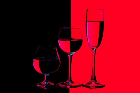 Three Different in Height Glass Cups Placed in One Line Against Vivid  Black And Red Background.