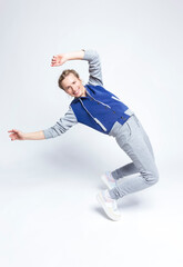 Active Flexible Female In Streetwear During Body Flex and Stretching Exercises On White Background.