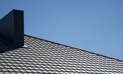 Brown corrugated metal profile roof installed on a modern house. The roof of corrugated sheet. Roofing of metal profile wavy shape. Modern roof made of metal. Metal roofing.