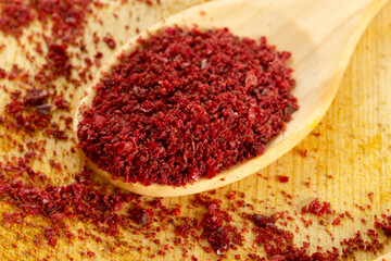  Red pepper  flakes in a wooden spoon