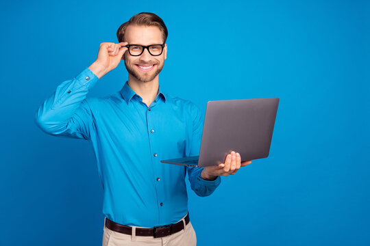 Photo of young business man happy positive smile hand touch glasses use laptop isolated over blue color background