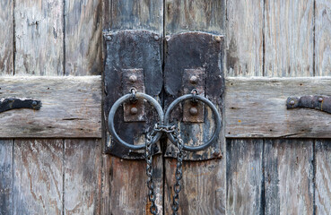 Wooden doors with iron handles and chains.