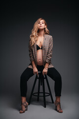 Young beautiful pregnant woman in jacket on black background