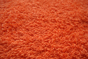 Orange color bath towel texture with blur effect.