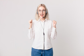 blond pretty woman feeling shocked,laughing and celebrating success telemarketing concept