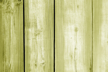 Wall made of uncutted weathered wood boards in yellow color.
