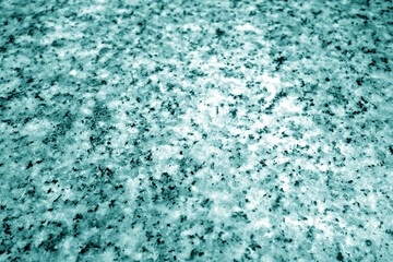 Granite surface as background with blur effect in cyan tone.