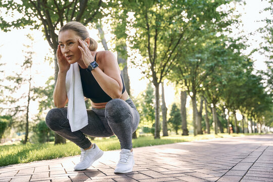 Do It For Yourself. Tired Middle Aged Athletic Woman In Sportswear Looking Away, Resting While Training In Green Park On Sunny Day