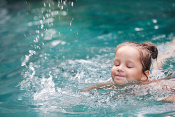Pretty little girl in swimming pool