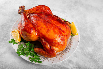  Whole baked chicken in sauce with paprika on a plate and light gray background