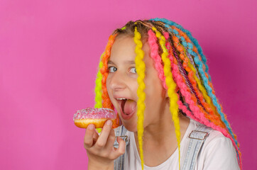 girl with colored dreads and sweet donut on pink background