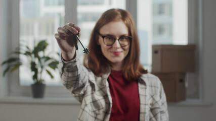 Fototapeta premium Girl with glasses showing off the keys to the apartment