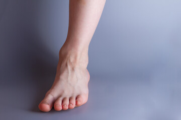 One leg of a 7-year-old baby boy on a gray background. Copy space