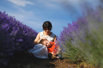 boy laying on mother's knees in lavender