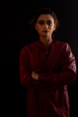 Portrait of young girl looking at camera. Face close-up. Sad expression. Black background