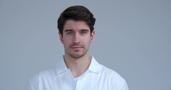 Portrait of handsome doctor or scientist wearing a white coat looking at camera, isolated on white background. 