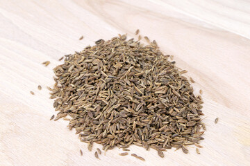 Cumin isolated on a wooden background. Caraway seeds. Heap of cumin