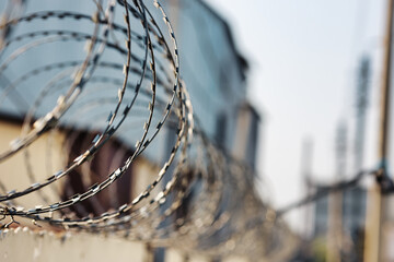 Spirals of barbed wire on a concrete fence. A symbol of incarceration and lack of freedom.