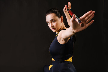 Horting sports woman with stick doing different stance on black background