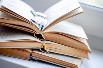 Open book on a window sill, illuminated by sunlight.