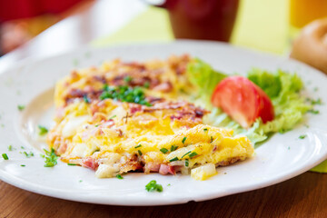 Omelet with ham, tomato and green salad