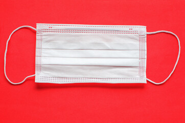 Coronavirus. Protective medical face mask on a red background