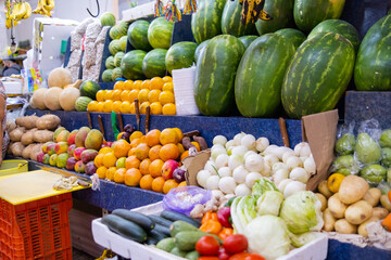 Colorful fruit stand with watermelons, oranges, mangoes, and more