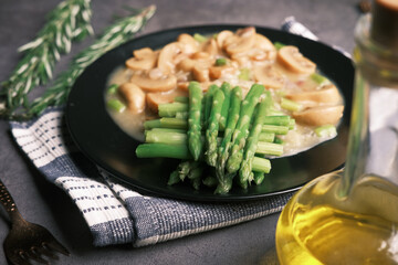 Asparagus green, olive oil and mushroom on plate black background 