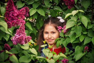 Portrait of a little girl near a blooming lilac