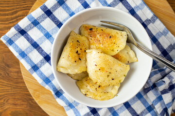 Pan-fried dumplings in a white bowl. Traditional dinner.