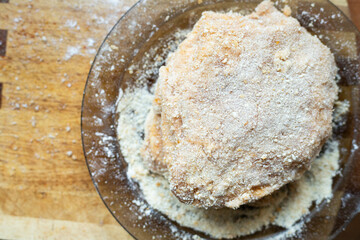Breaded pork chop lying on a plate. Traditional dinner.