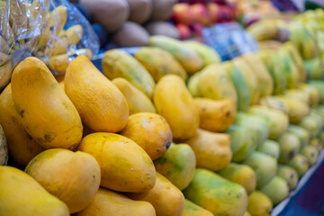 Colorful fruit stand with mangoes, small bananas, and more