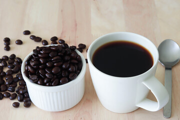 top view of cup of coffee and coffee beans on wood background