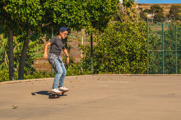 Caucasian boy with cap skating with his skateboard in a skate park