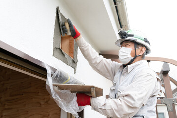 左官　職人　イメージ　外壁作業　換気扇まわり