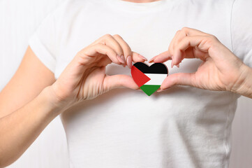 Flag of Palestine in the shape of a heart in the hands of a girl. Love Palestine. The concept of...