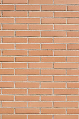 Brick wall with clean orange bricks. Background vertical texture.