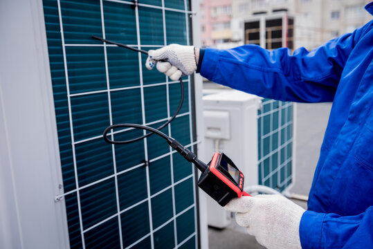 the technician uses a digital camera to check the clogging of the heat exchanger